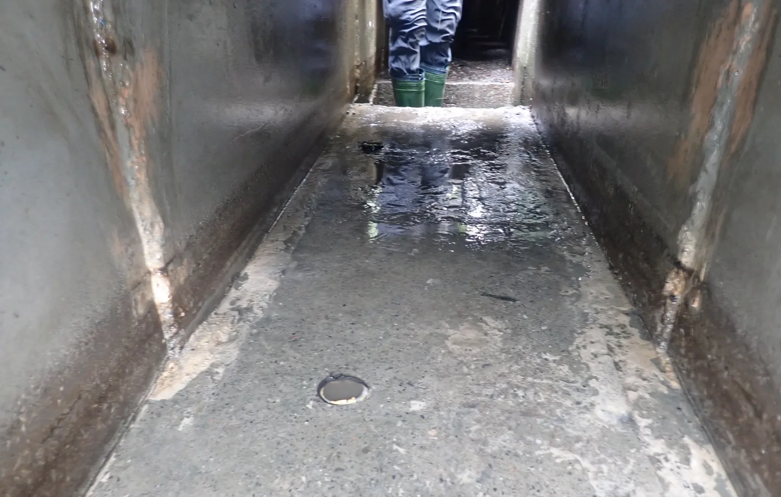 清理後的箱涵,盡頭站著一位穿雨鞋的師傅